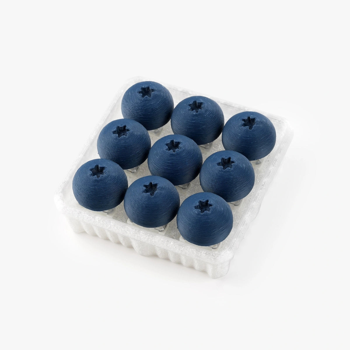 Nine blue blueberries arranged in a clear plastic clamshell container on a clean white background.