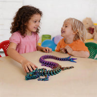 Kids playing with colorful 3D printed articulated Dragon