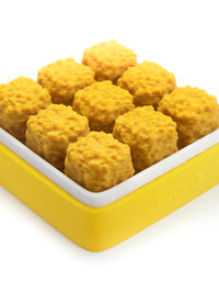 Yellow and white square container holding snack pieces